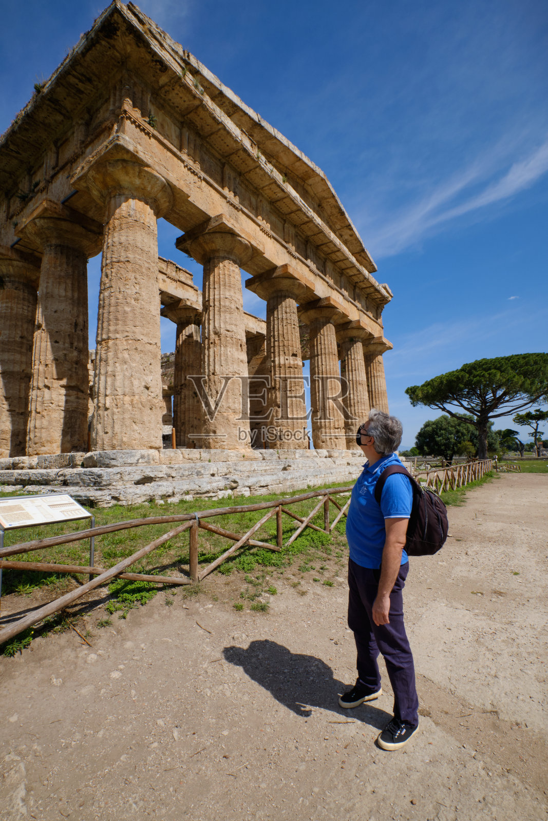 意大利帕埃斯图姆希腊神庙下戴面具的游客照片摄影图片