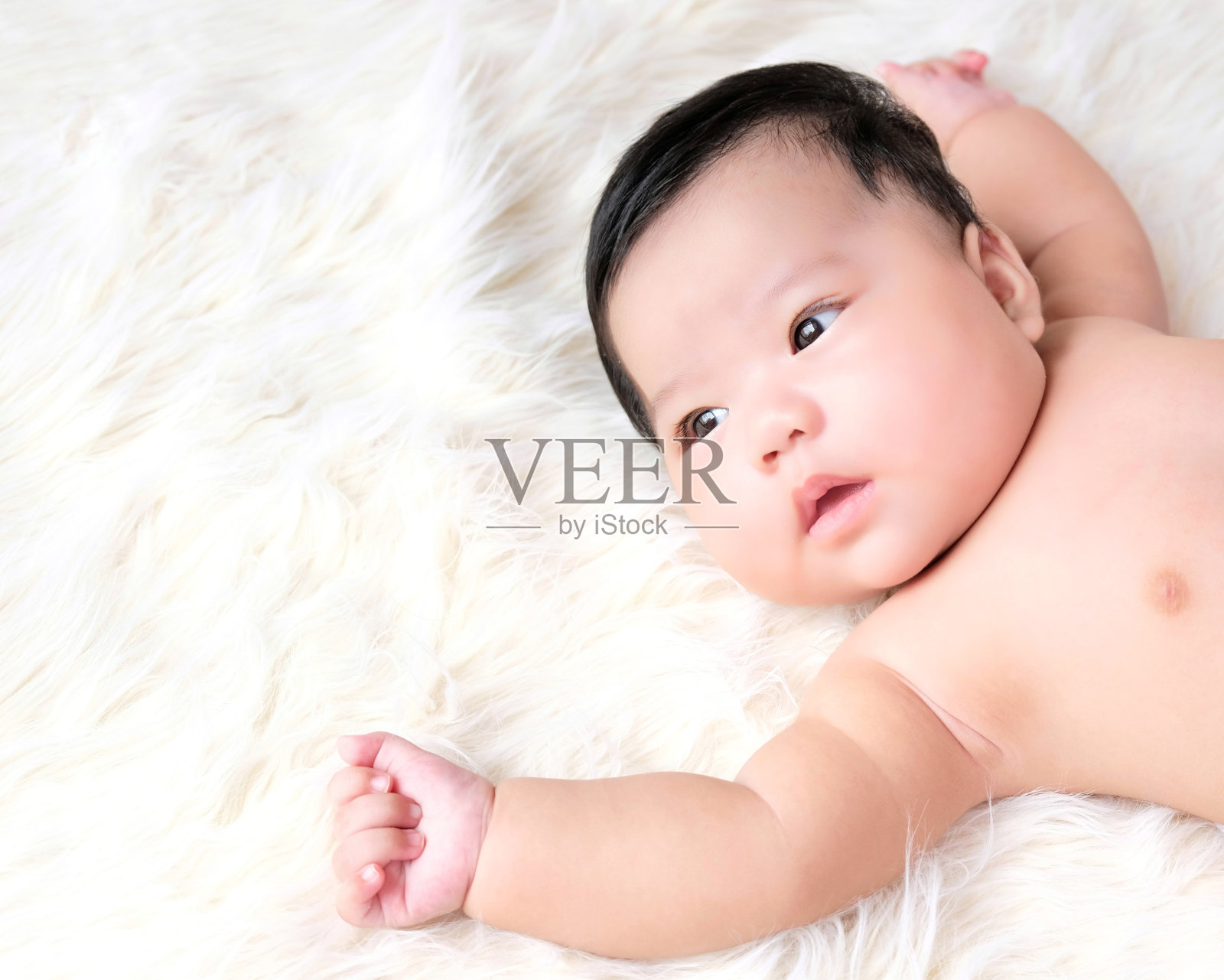 在白色背景下睡觉的婴儿的特写。照片摄影图片