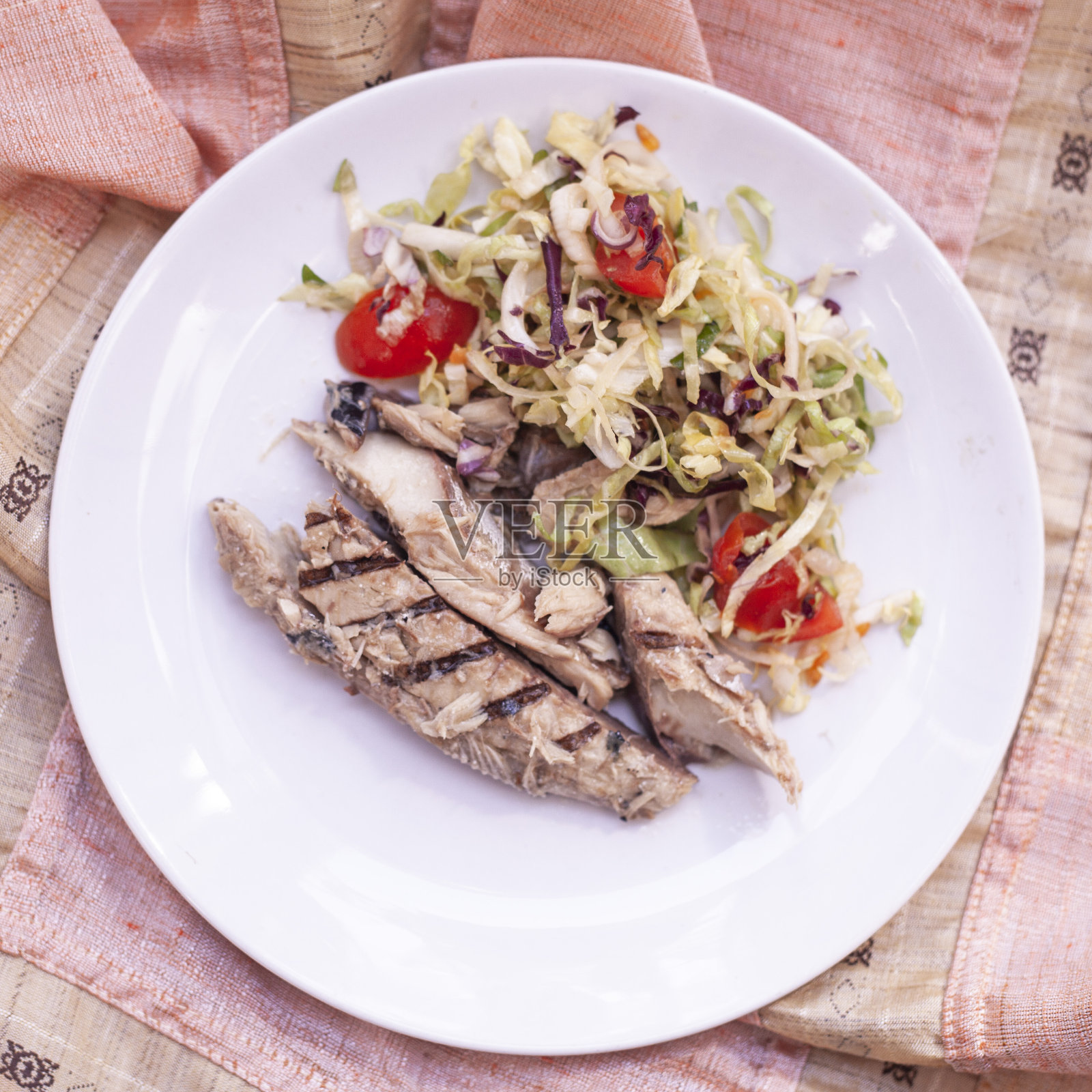 烤鲭鱼片配新鲜沙拉和樱桃番茄。照片摄影图片