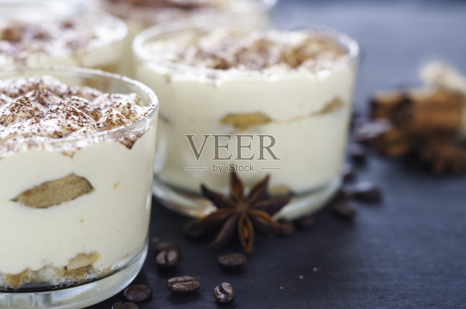 精美的提拉米苏在玻璃装饰可可粉在黑暗的背景照片摄影图片