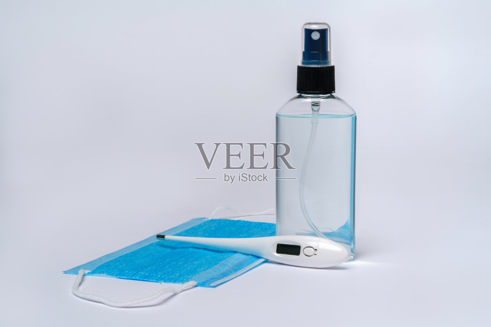 瓶子的洗液,消毒剂或液体肥皂,电子温度计和保护口罩在浅灰色背景照片摄影图片