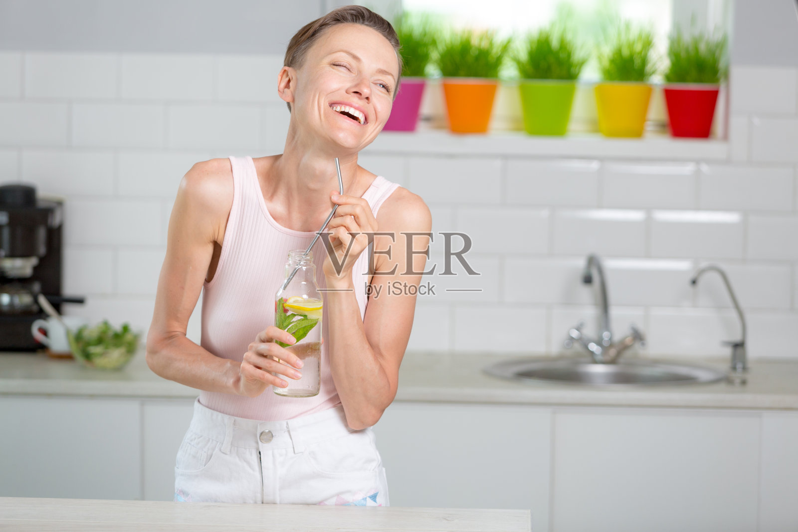 一个漂亮的女人拿着一瓶柠檬薄荷草莓水照片摄影图片