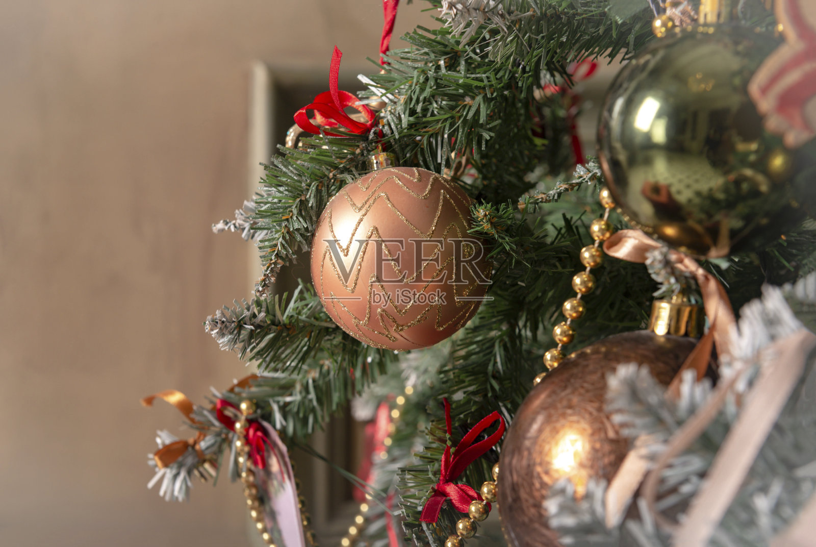 把金球挂在圣诞树上,装饰房间照片摄影图片
