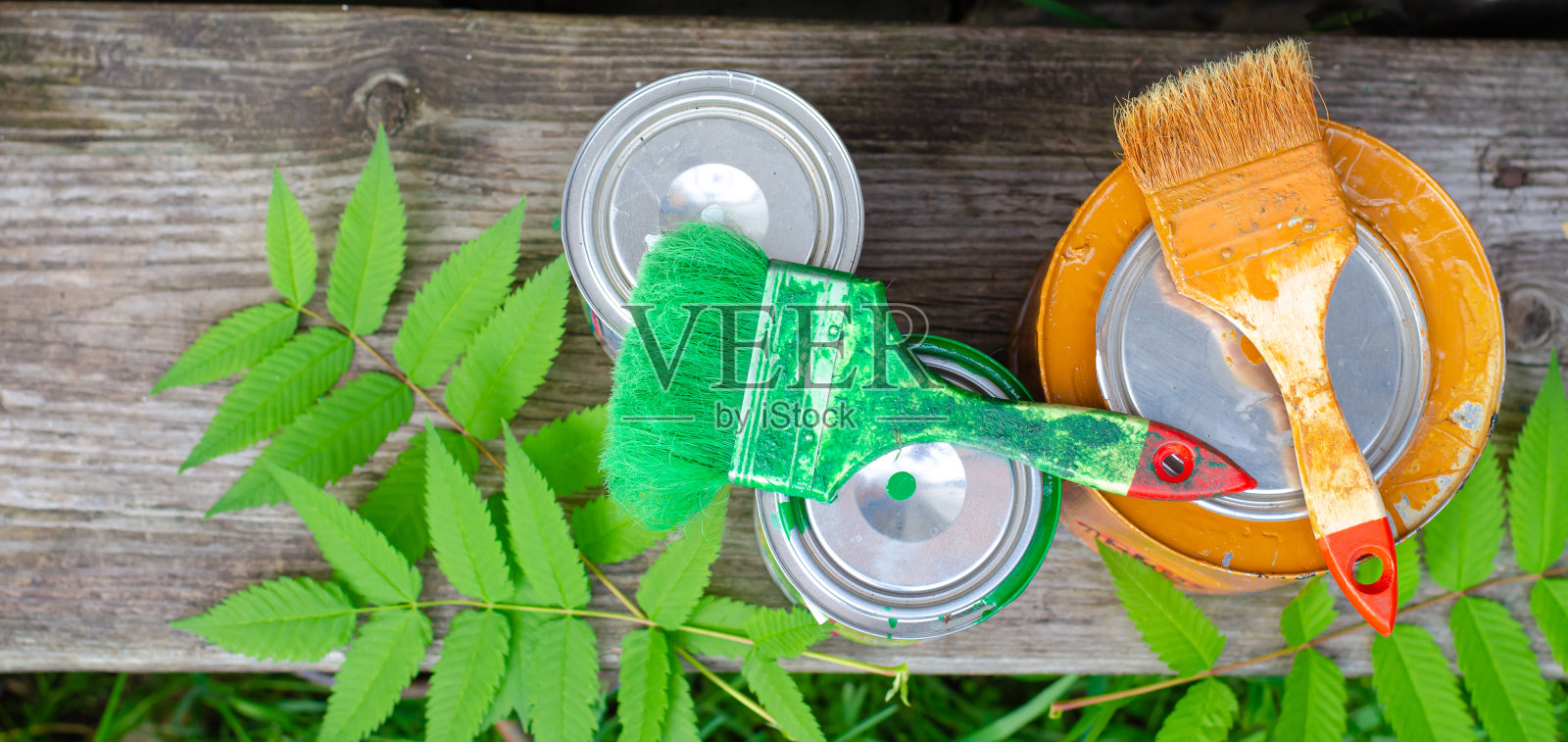 木凳上放着画笔和丙烯酸颜料罐。概念DIY,家居装修。照片摄影图片