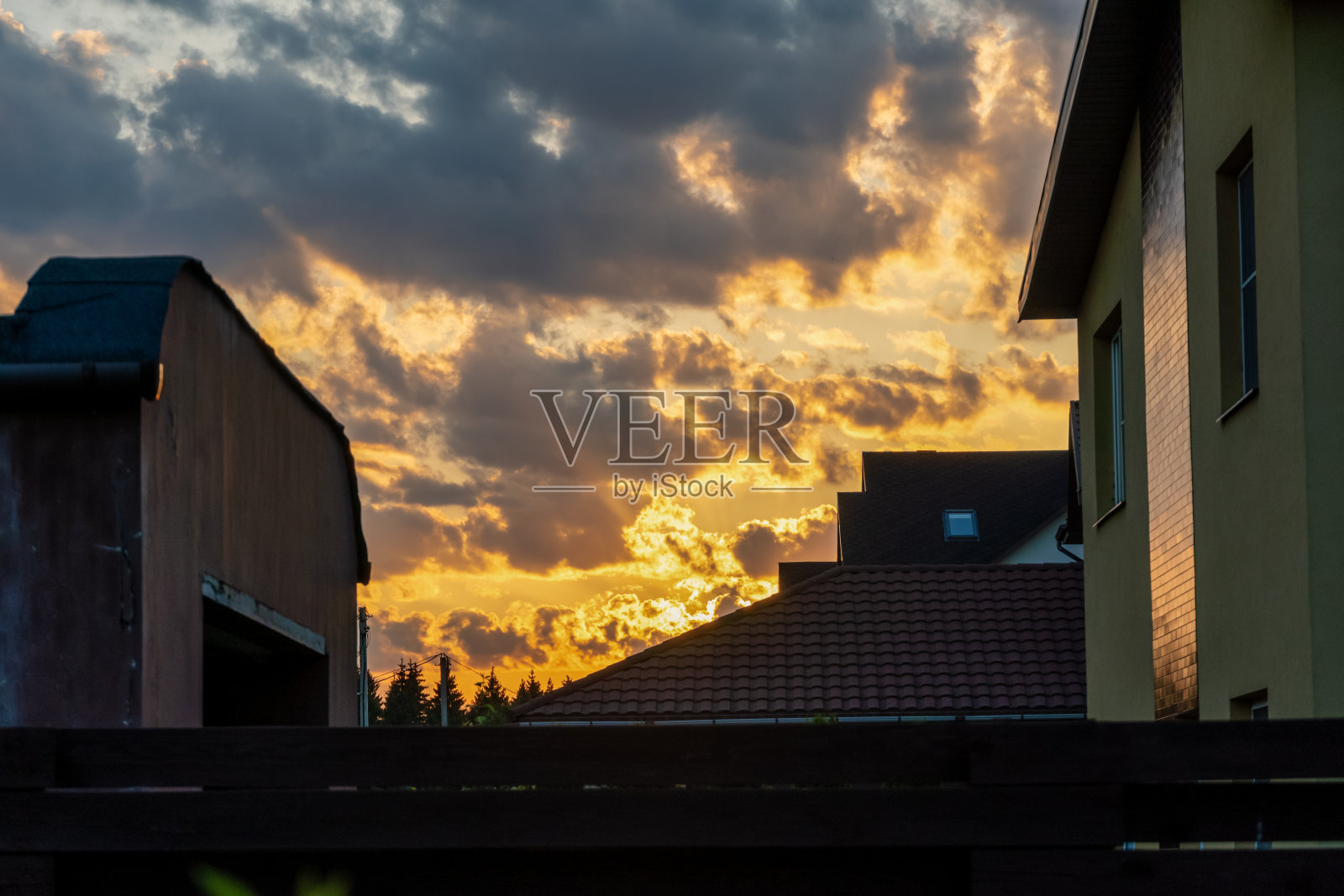 美丽的橙色夕阳映衬在一个乡村的现代村舍上照片摄影图片