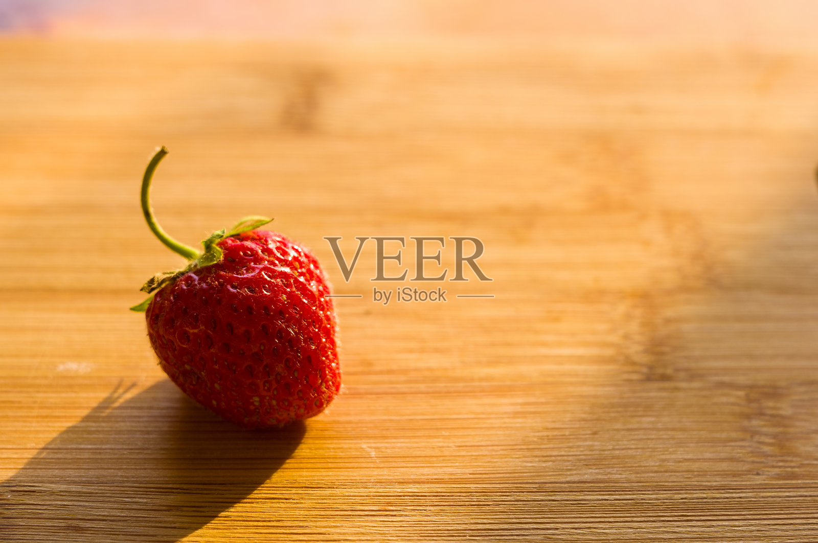 新鲜成熟的草莓放在竹板上,近距离观察照片摄影图片