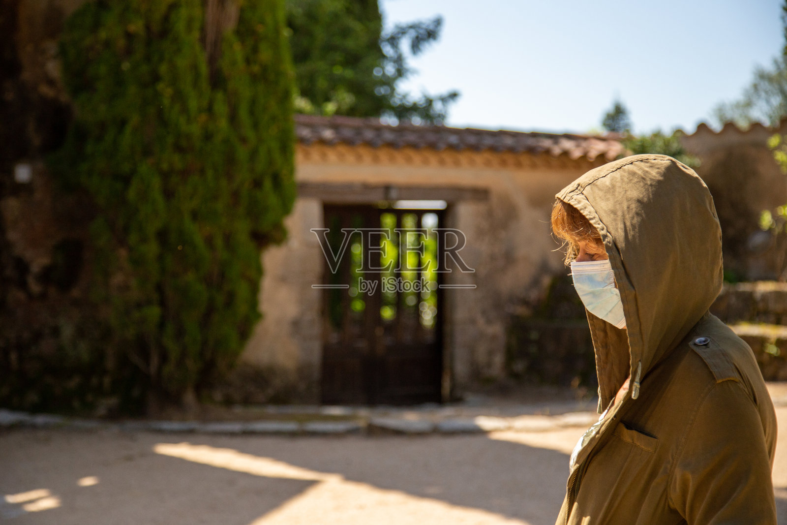 戴着口罩的沮丧兜帽女人照片摄影图片