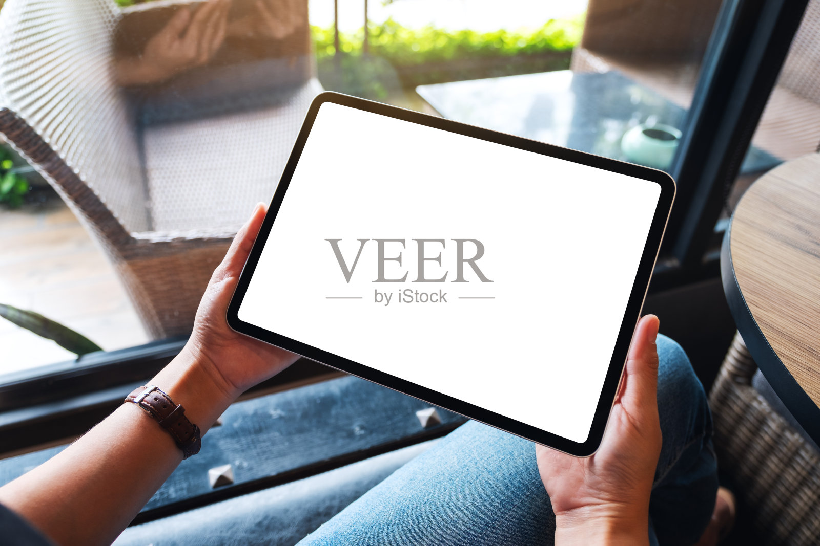 一个女人拿着黑色平板电脑和空白的白色桌面屏幕照片摄影图片