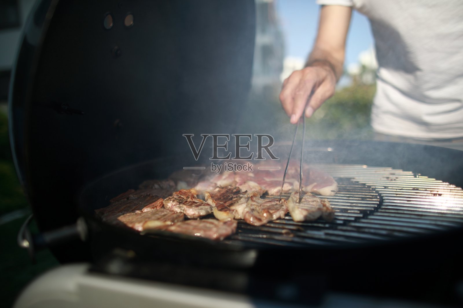 在后院与家人烧烤,父子在花园烧烤肉类照片摄影图片