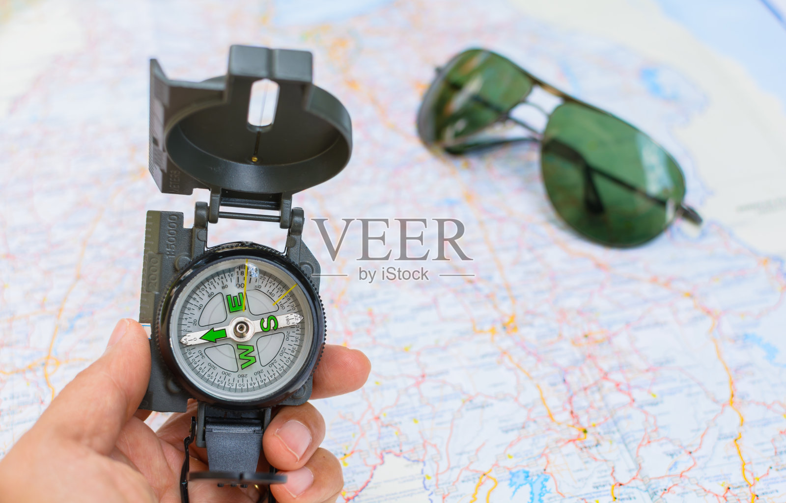 旅行者手中的磁罗盘。照片摄影图片