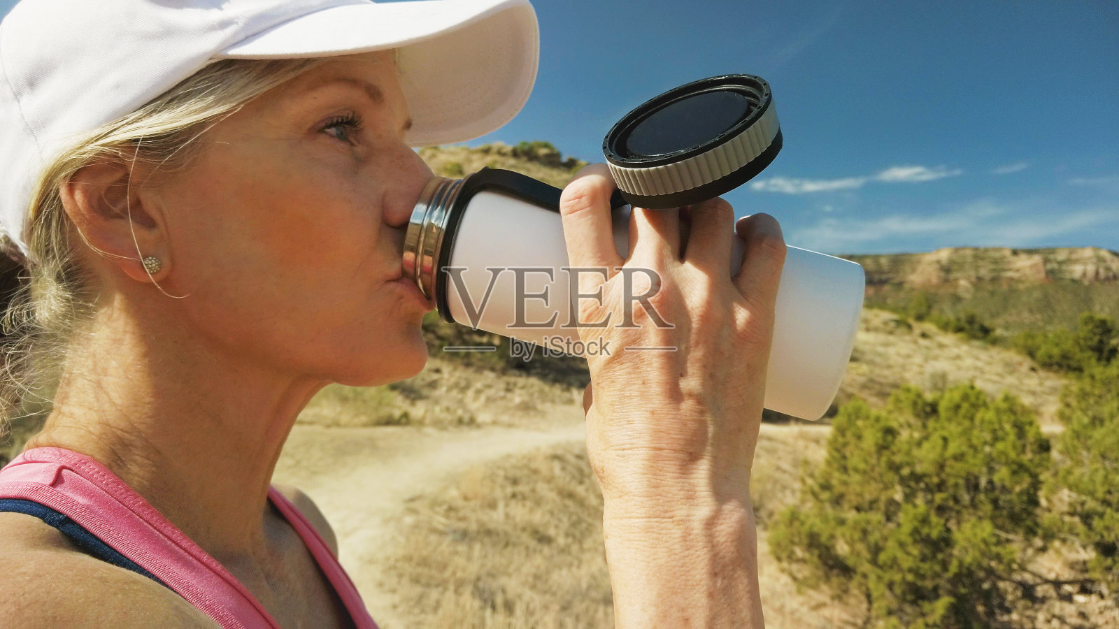 一个阳光明媚的夏天,在科罗拉多西部干旱的高沙漠徒步旅行的成熟成年女性饮水照片摄影图片