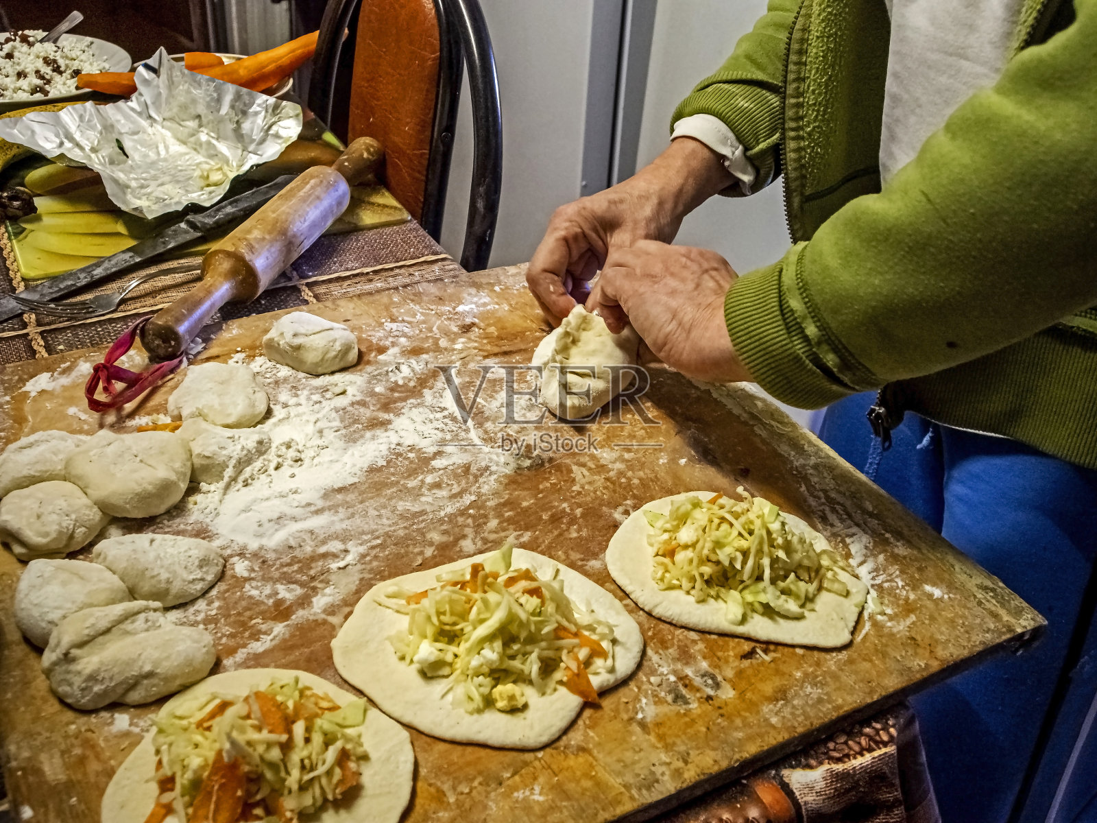 生馅饼,用馅夹住馅饼的边缘照片摄影图片