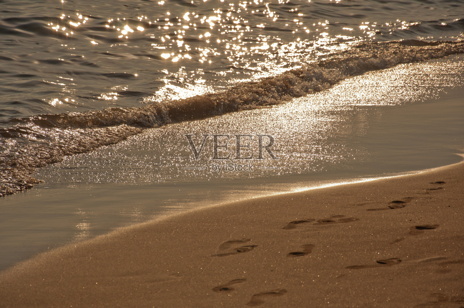 沙滩上的海浪和脚印。自然背景。照片摄影图片