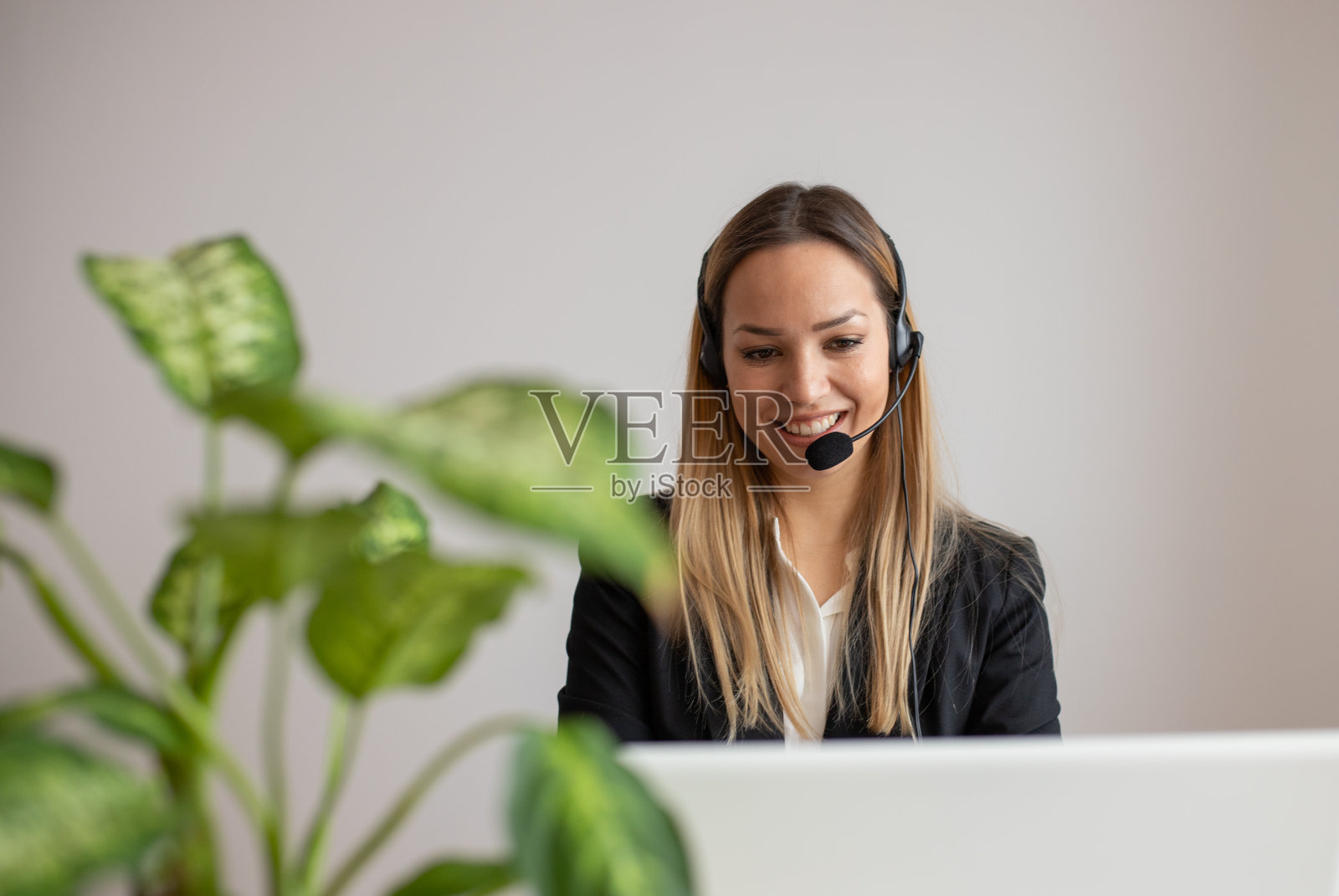 在呼叫中心工作的年轻女性。办公室里的客服女士照片摄影图片