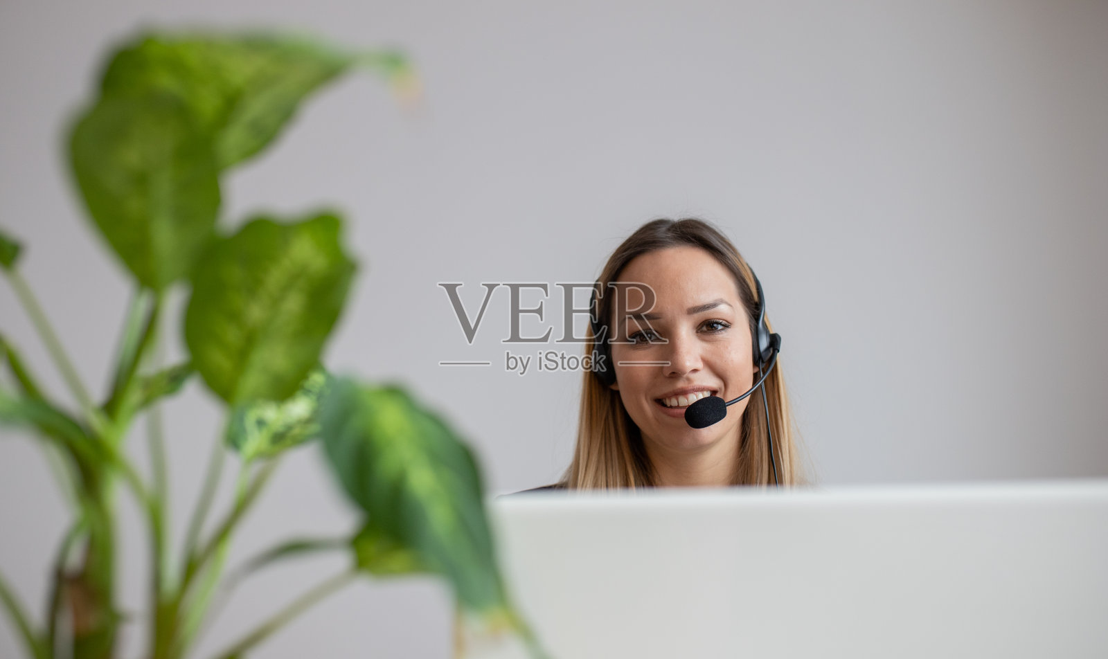 在呼叫中心工作的年轻女性。办公室里的客服女士照片摄影图片