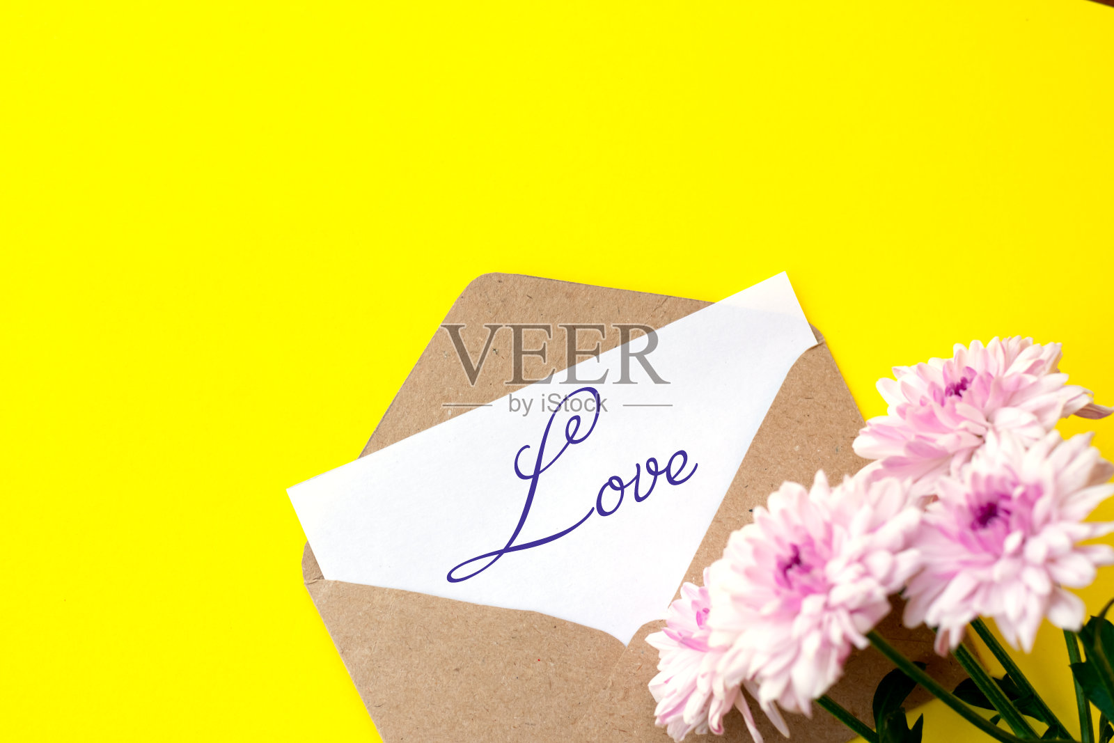 爱的信封和信上写着爱与粉红色的菊花照片摄影图片