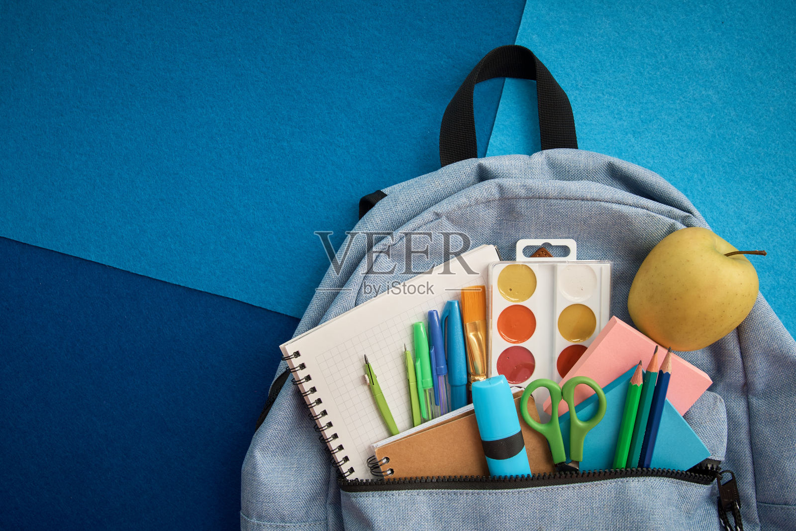 蓝色背景的背包文具套装。学校用品俯视图为广告和促销项目。返校理念照片摄影图片