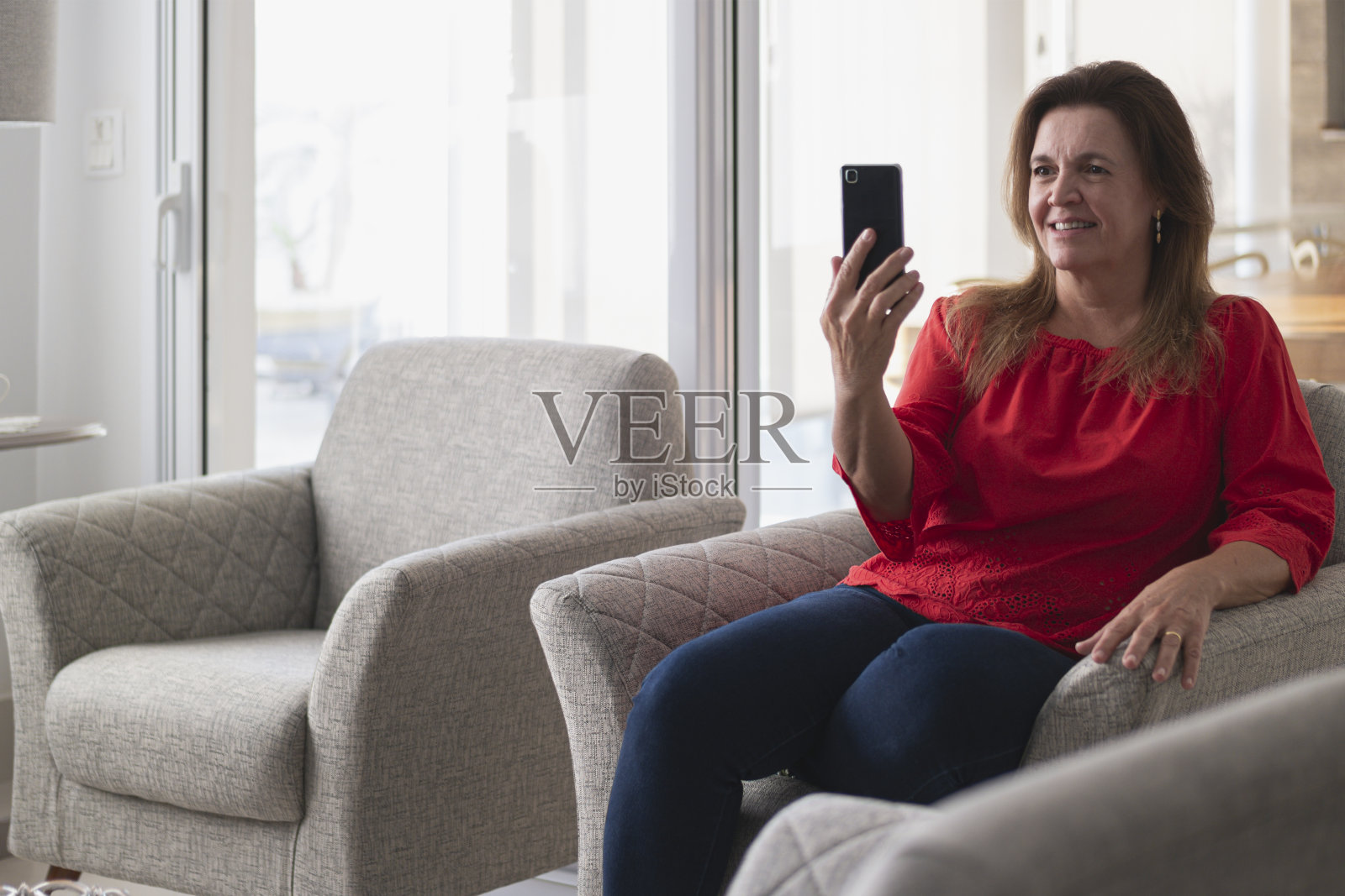 在家工作,手持手机的女性。照片摄影图片