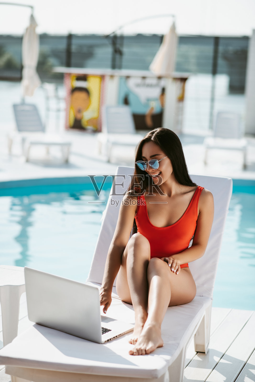 年轻的成年女子坐在躺椅上的笔记本电脑照片摄影图片