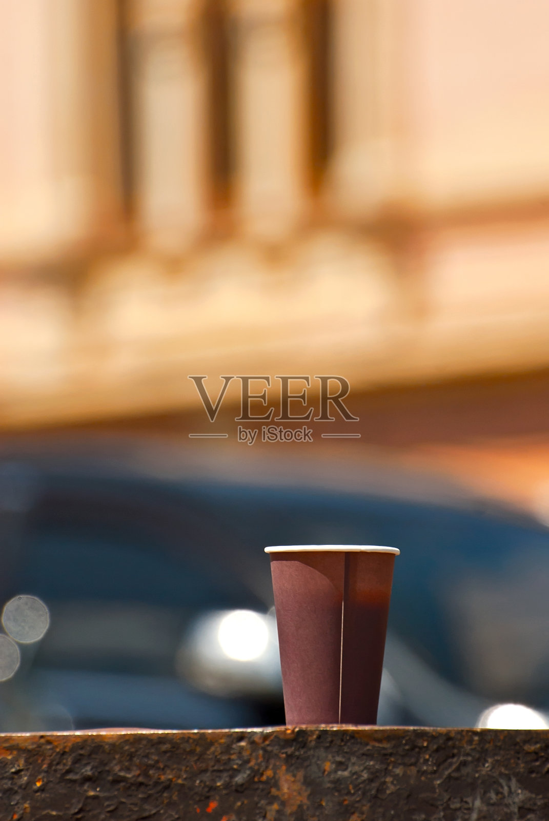 以城市建筑为背景的棕色纸杯。大理石镶边上的咖啡。老城的房屋在背景中显得模糊。清晰度上咖啡。布局设计。照片摄影图片