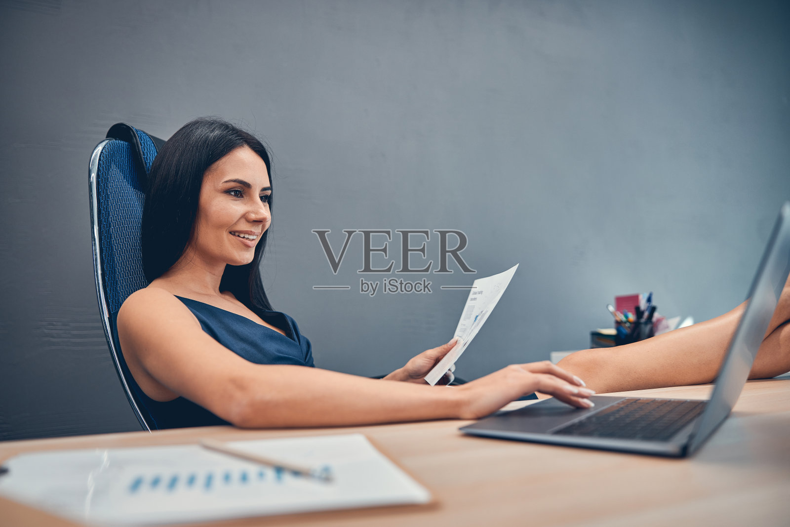 无忧无虑的女职员正把脚放在桌子上照片摄影图片