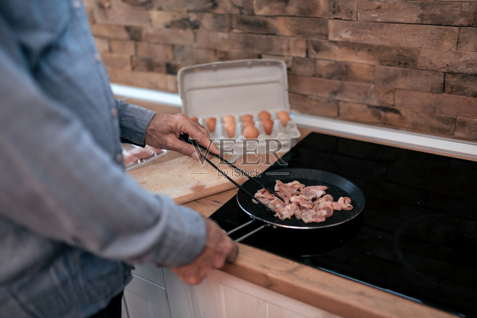 有人在做熏肉和鸡蛋当早餐。照片摄影图片