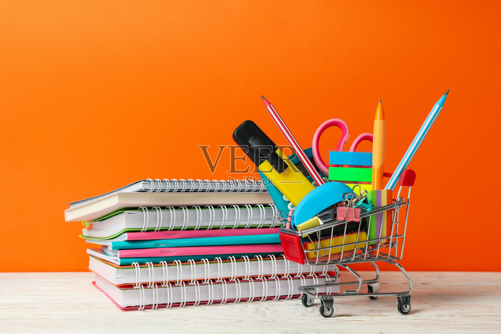 购物车与学校用品橙色背景,文字空间照片摄影图片