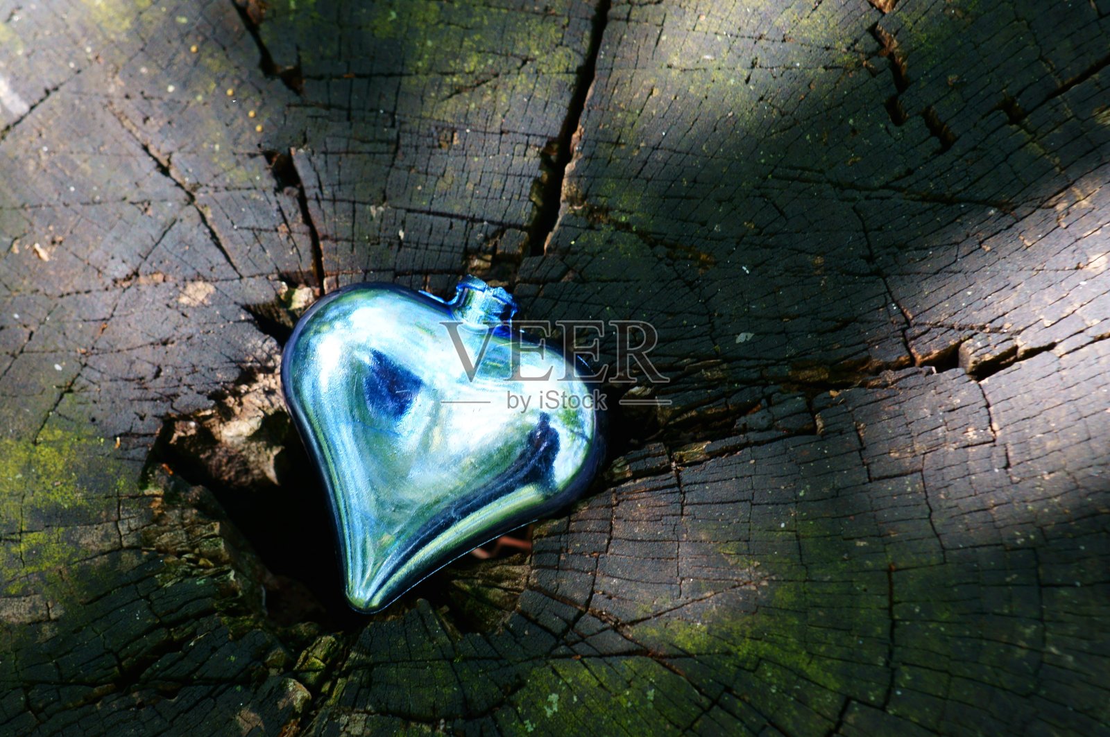 绿色背景上的蓝色心。照片摄影图片