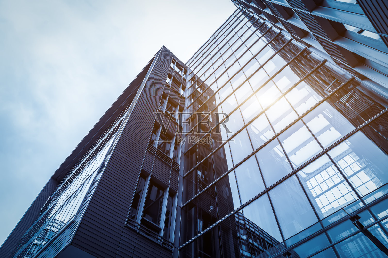 抬头看那座高层建筑的外墙玻璃。照片摄影图片