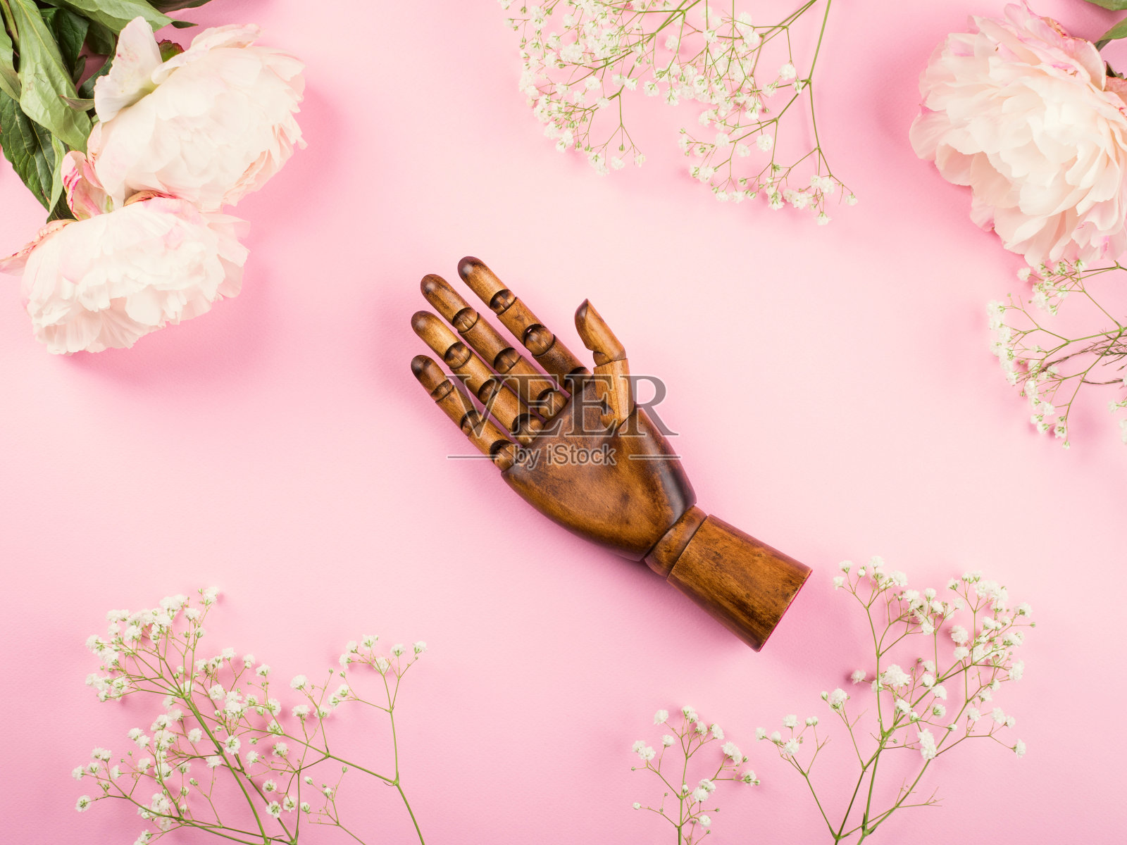 粉红色的背景,花朵和木制的手照片摄影图片