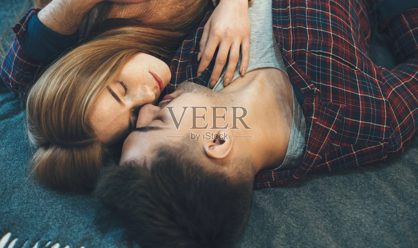 上图是一对白人夫妇面对面躺在床上睡觉的照片照片摄影图片