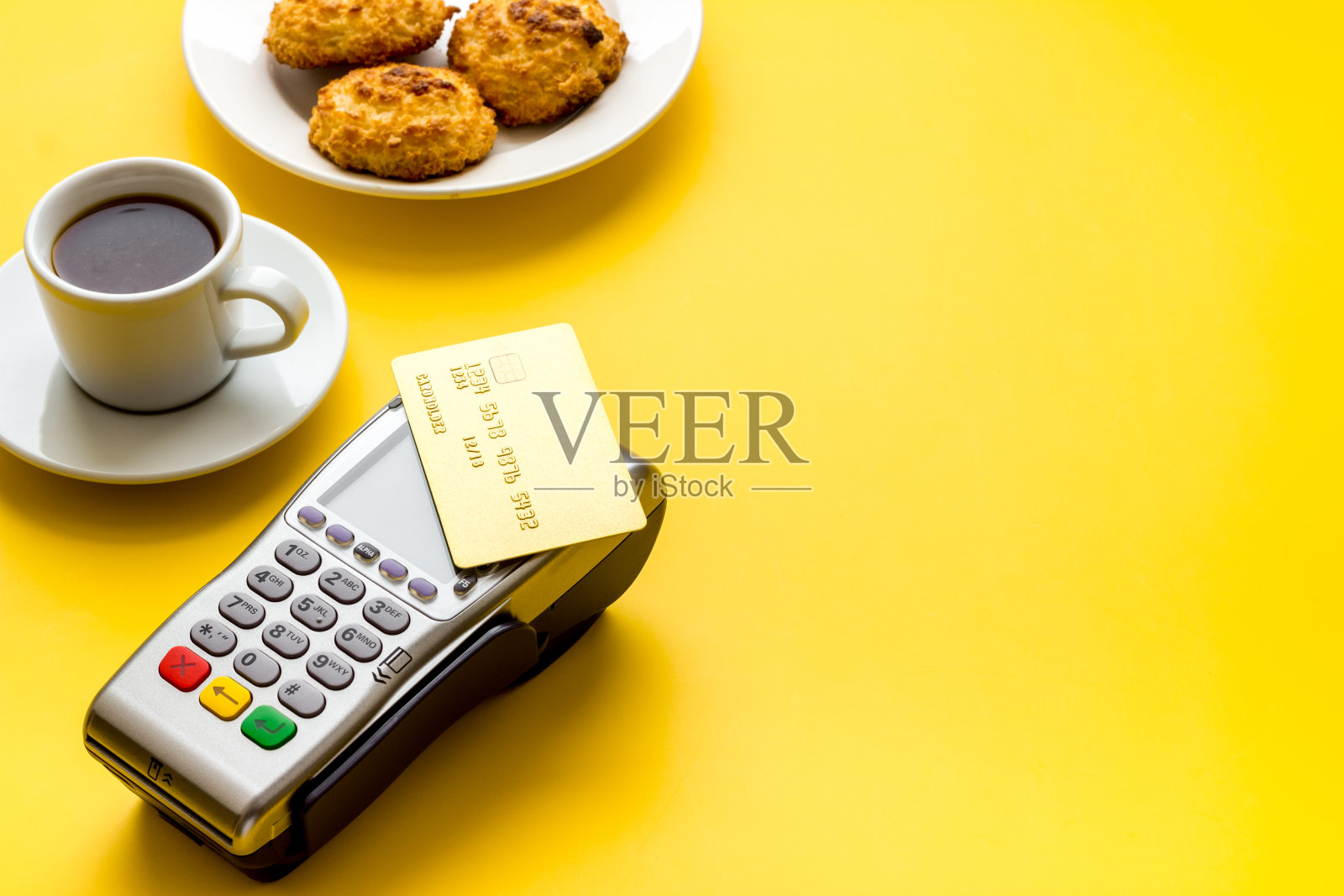 支付交易。终端和信用卡放在咖啡厅的黄色桌子上复印照片摄影图片