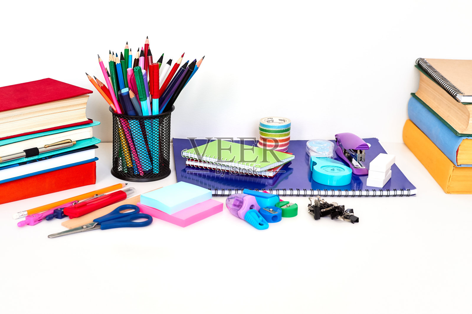 家庭办公书桌与书,笔记本和彩色文具在它上面的白色背景照片摄影图片