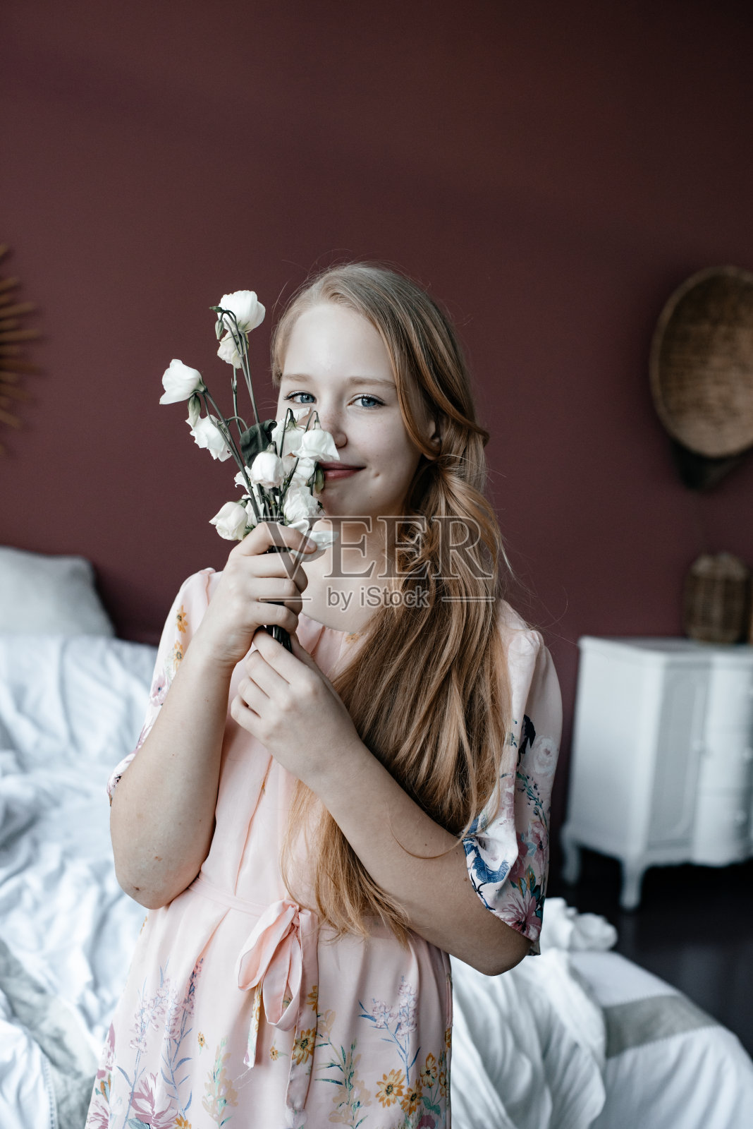 床上放着花的女孩。照片摄影图片