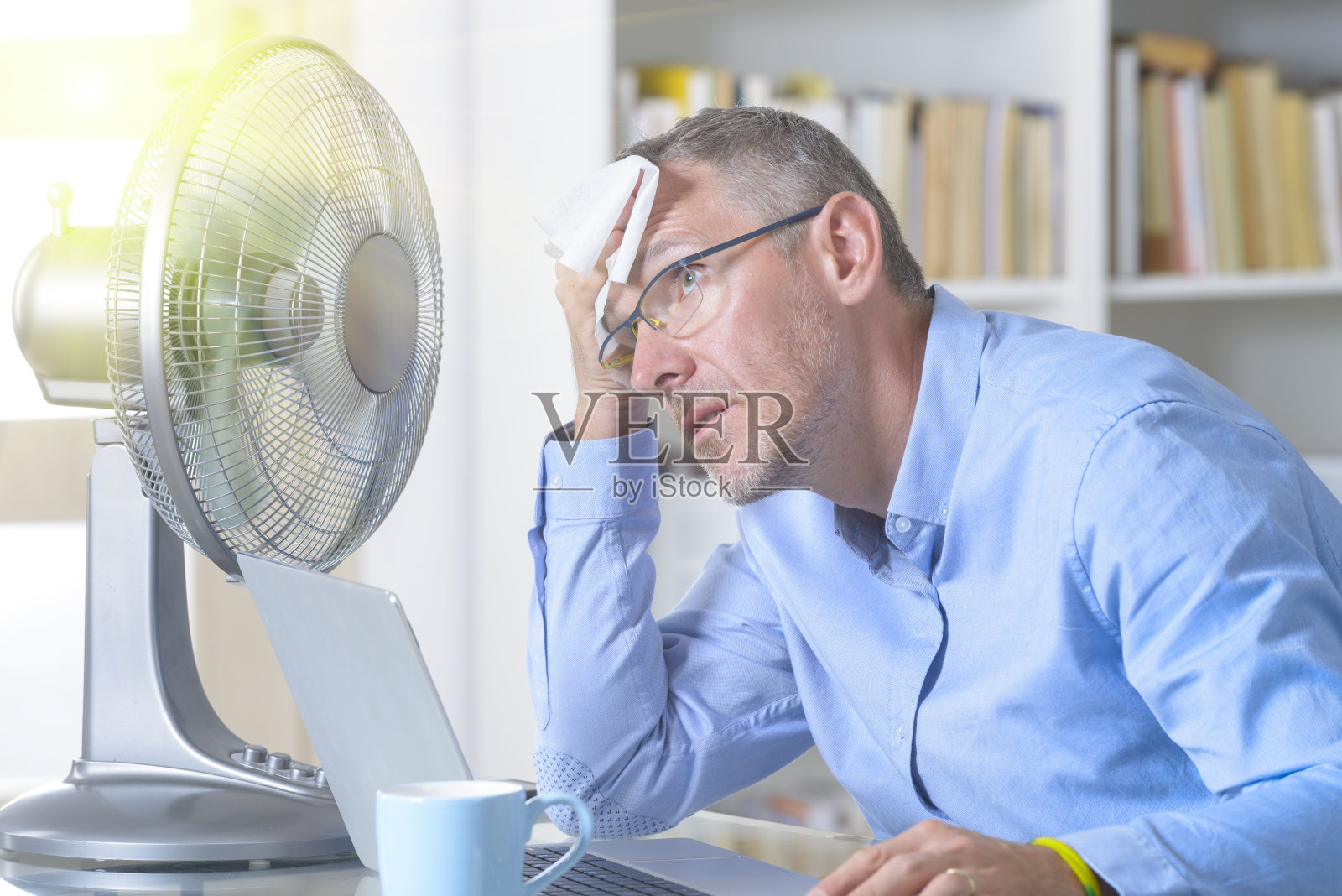 男人在办公室或家里受热之苦照片摄影图片