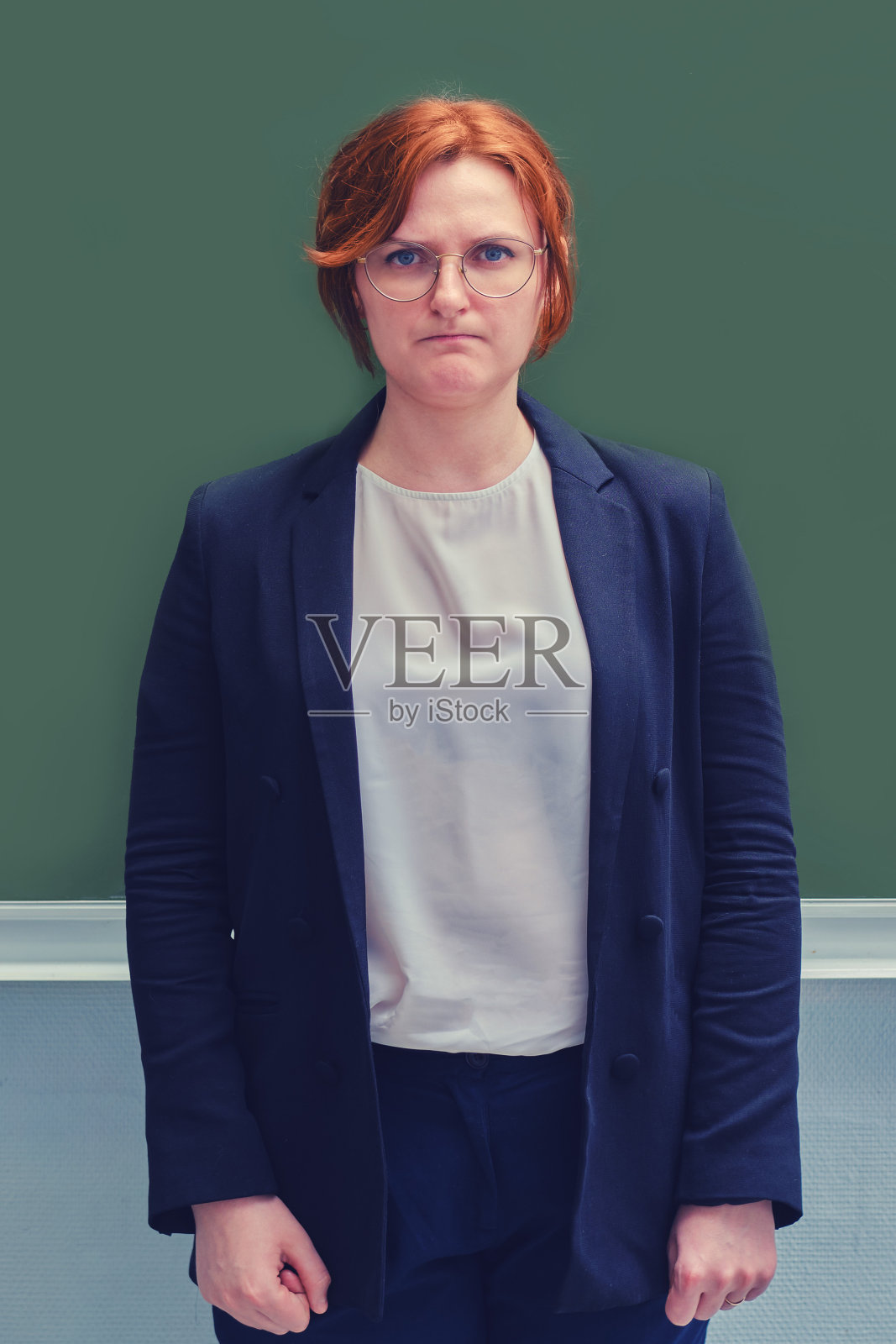 在学校黑板附近面带悲伤的年轻教师特写照片摄影图片