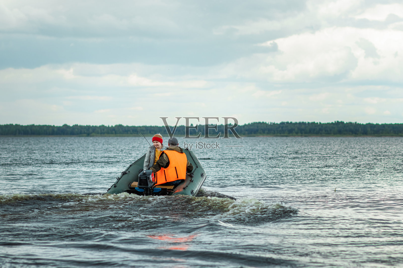 祖父和孙子在湖上乘坐摩托艇。家庭的概念,暑假,一代。副本的空间。照片摄影图片