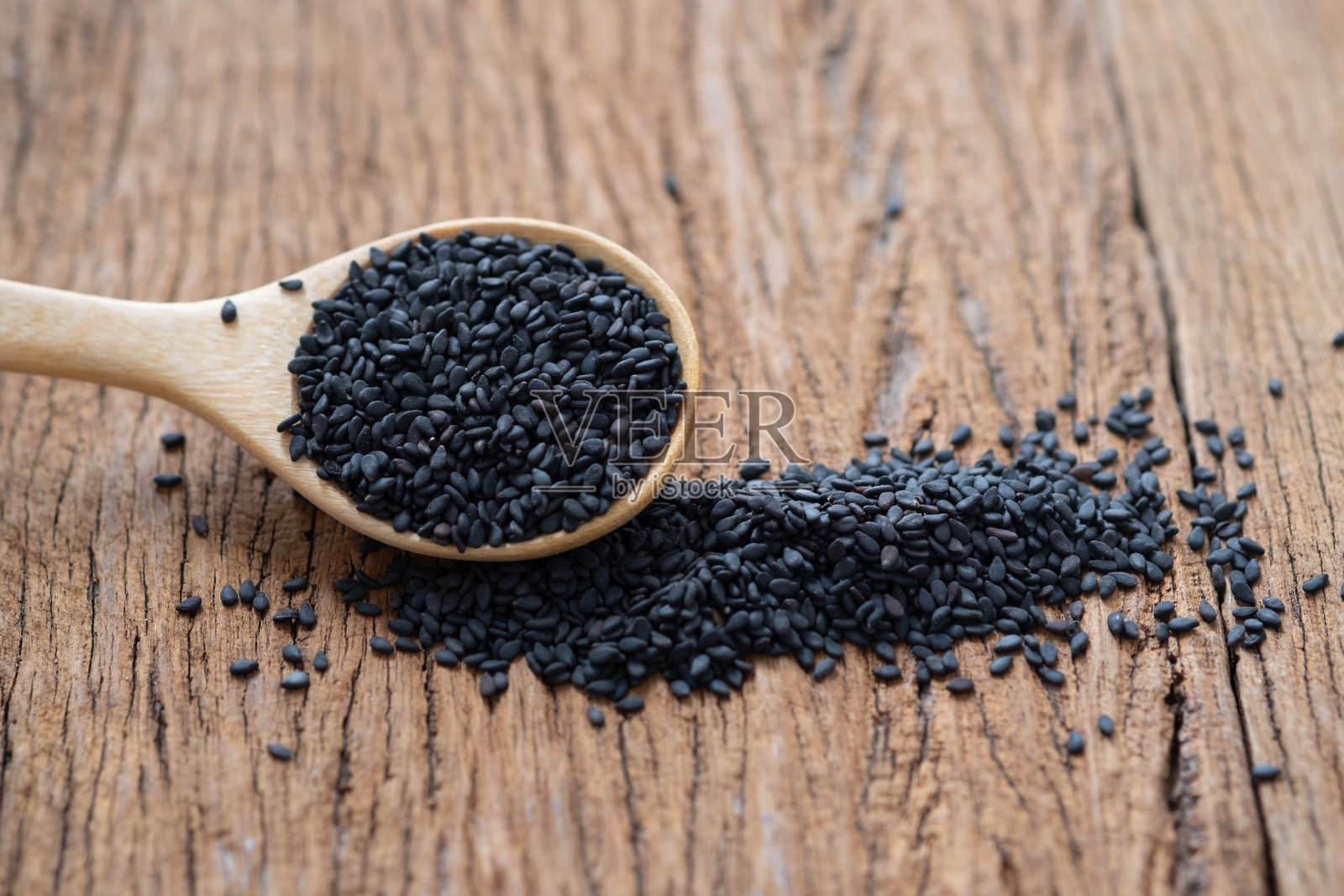 特写的有机天然黑芝麻种子在木桌的背景木勺。有机天然生食,烹饪健康素食照片摄影图片