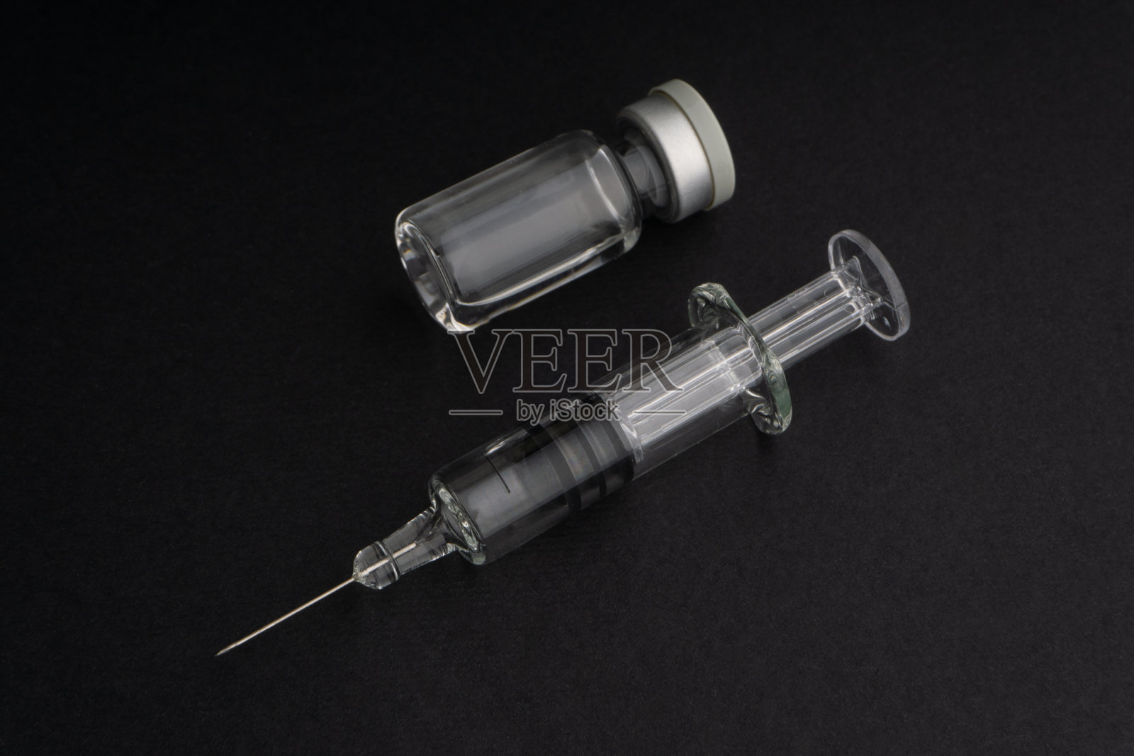 特写注射器和小瓶在黑色背景照片摄影图片