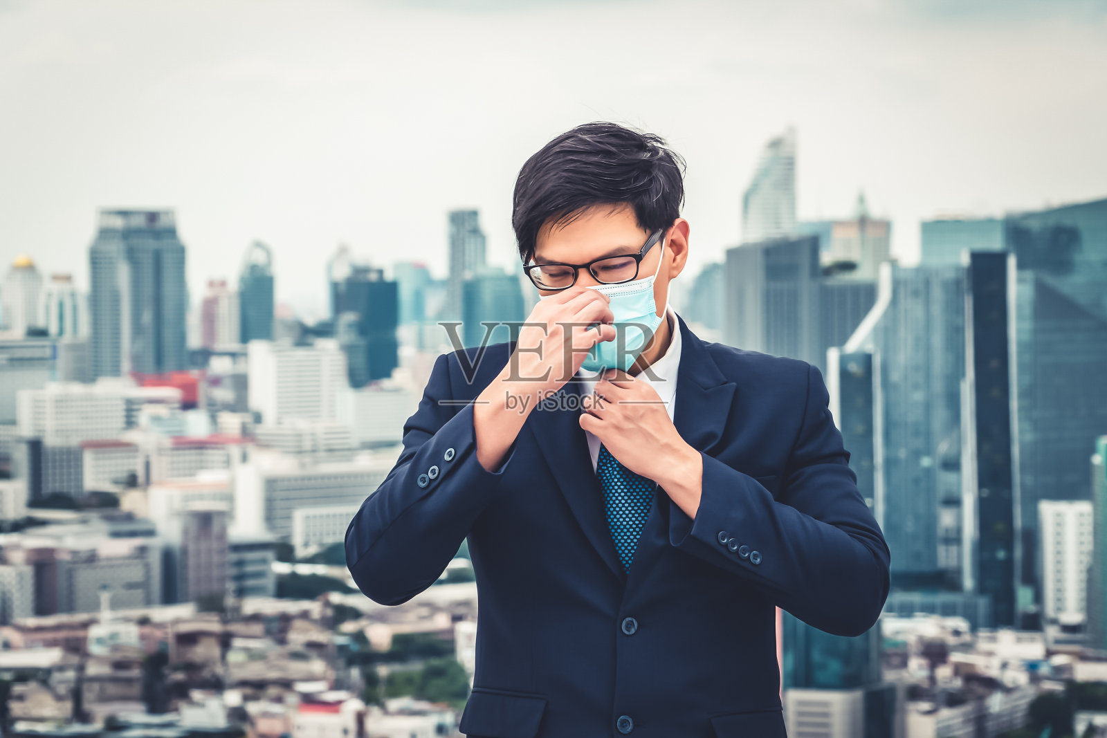 年轻白领戴口罩,与冠状病毒或COVID-19隔离。照片摄影图片