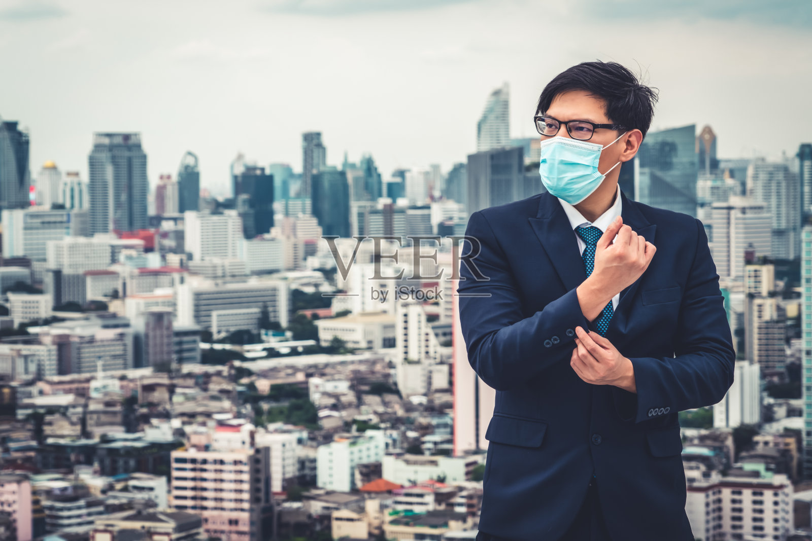 年轻白领戴口罩,与冠状病毒或COVID-19隔离。照片摄影图片