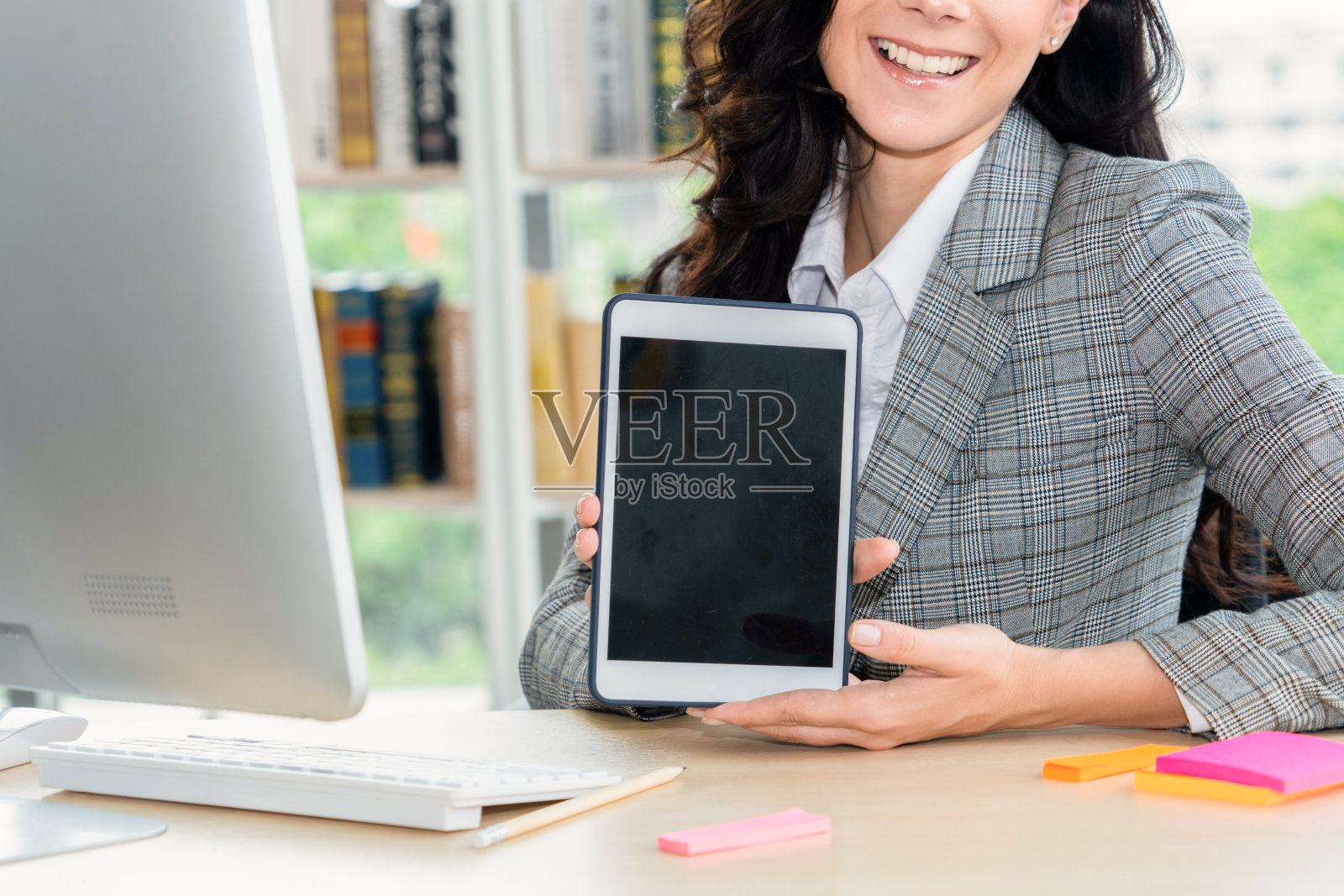 一名女性在办公室展示的空白平板电脑屏幕照片摄影图片