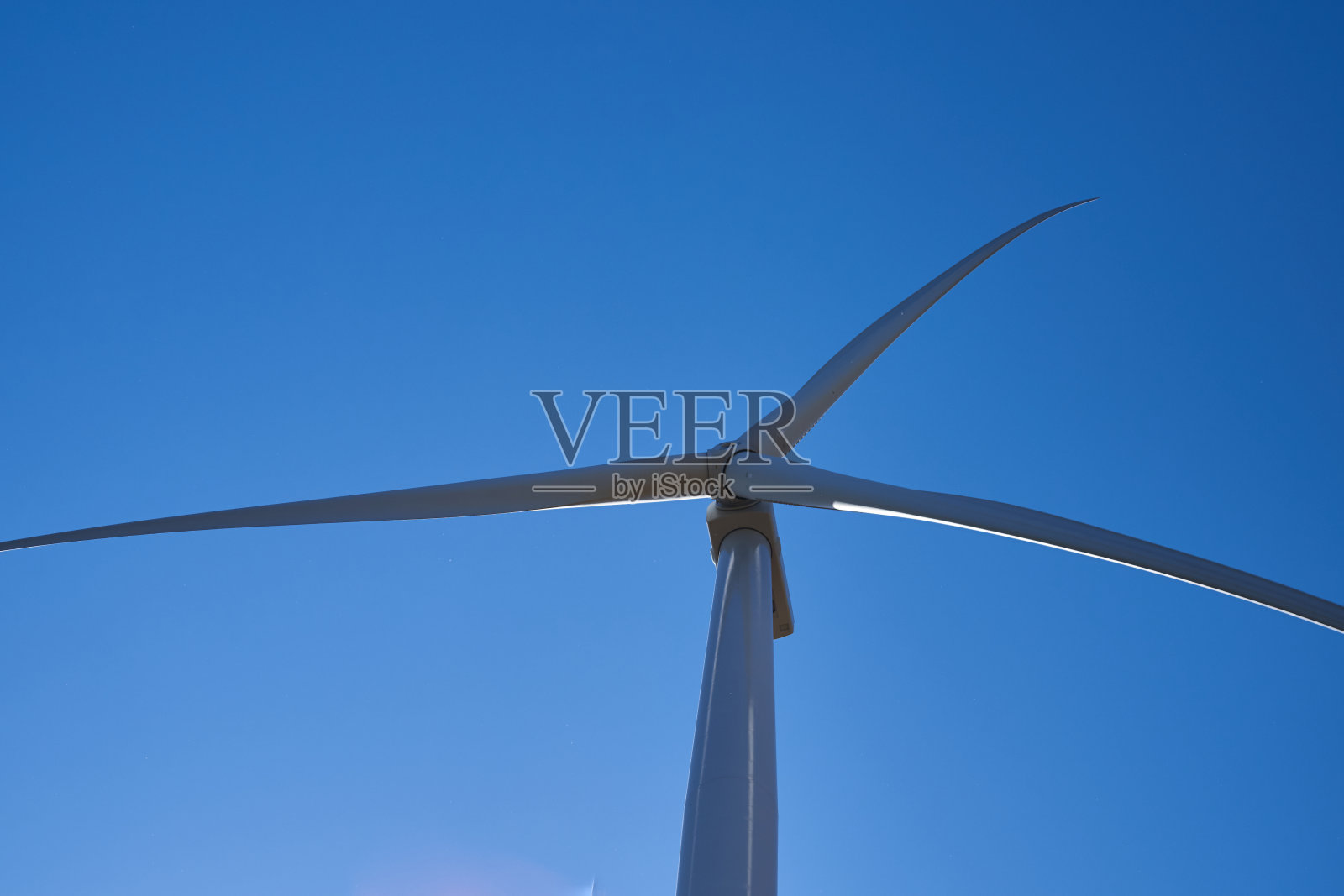 风力发电机矗立在城外的一块空地上照片摄影图片