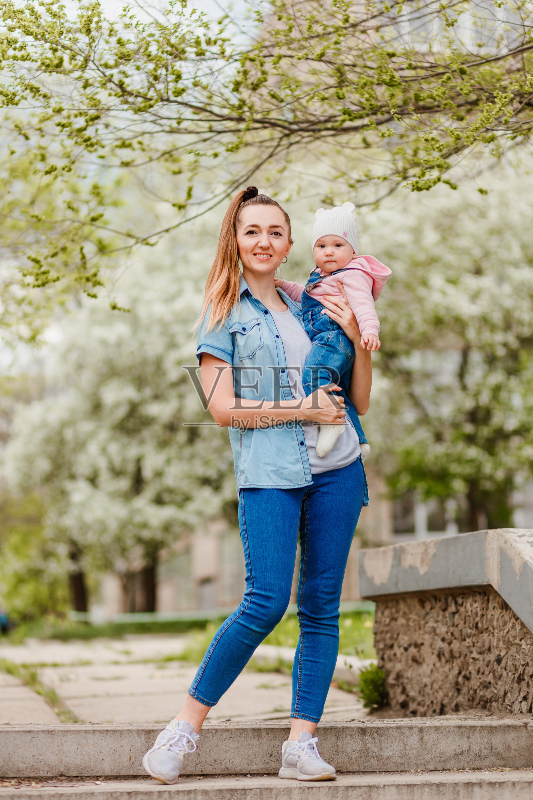 母亲和女儿在全长度牛仔夏天在公园。照片摄影图片