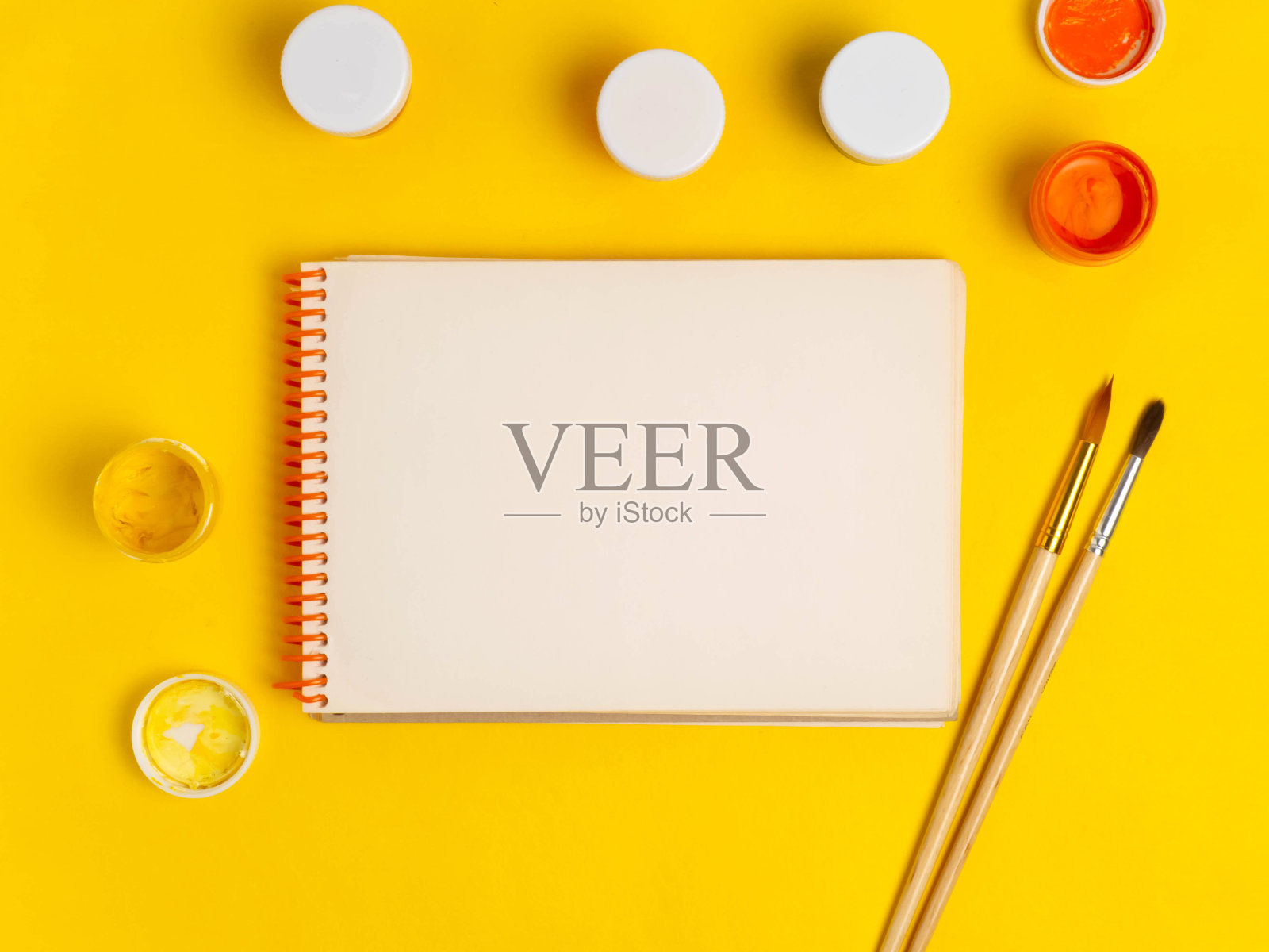 在黄色背景上绘制的项目:油漆,画笔,记事本。学习用品。空间的副本。照片摄影图片