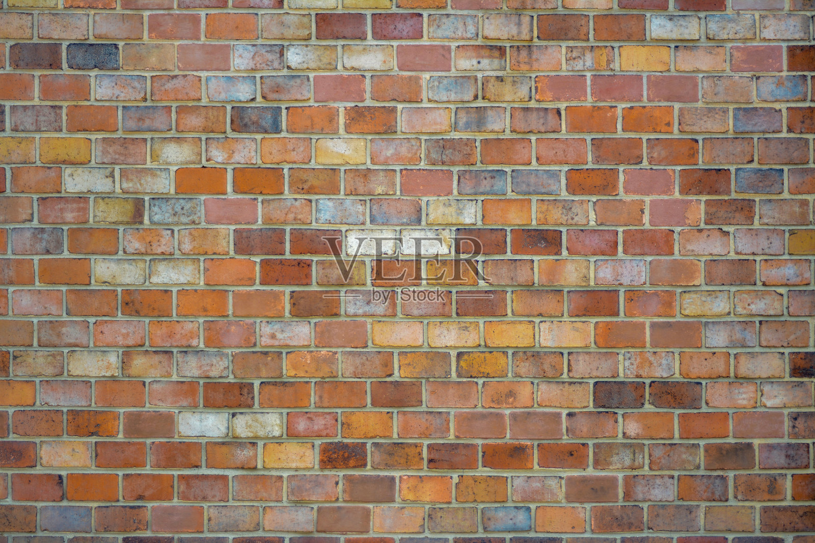 一堵由不同颜色的红砖砌成的墙照片摄影图片