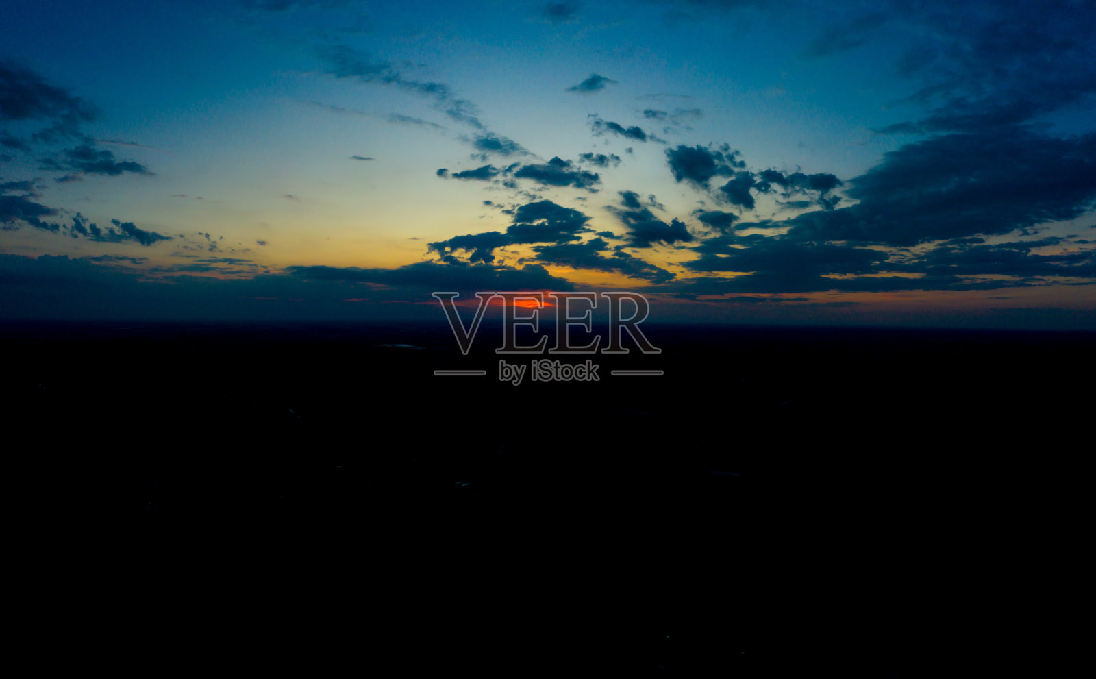 全景鸟瞰图美丽的绿色热带森林与雄伟的蓝天白云。日落照片摄影图片