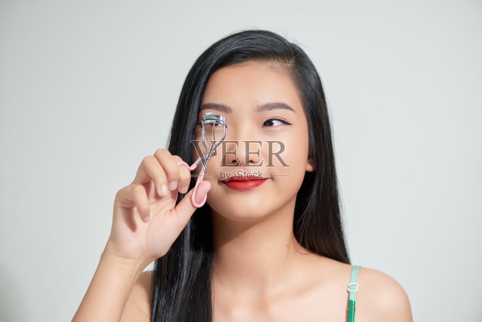 拿着睫毛工具的漂亮女人照片摄影图片