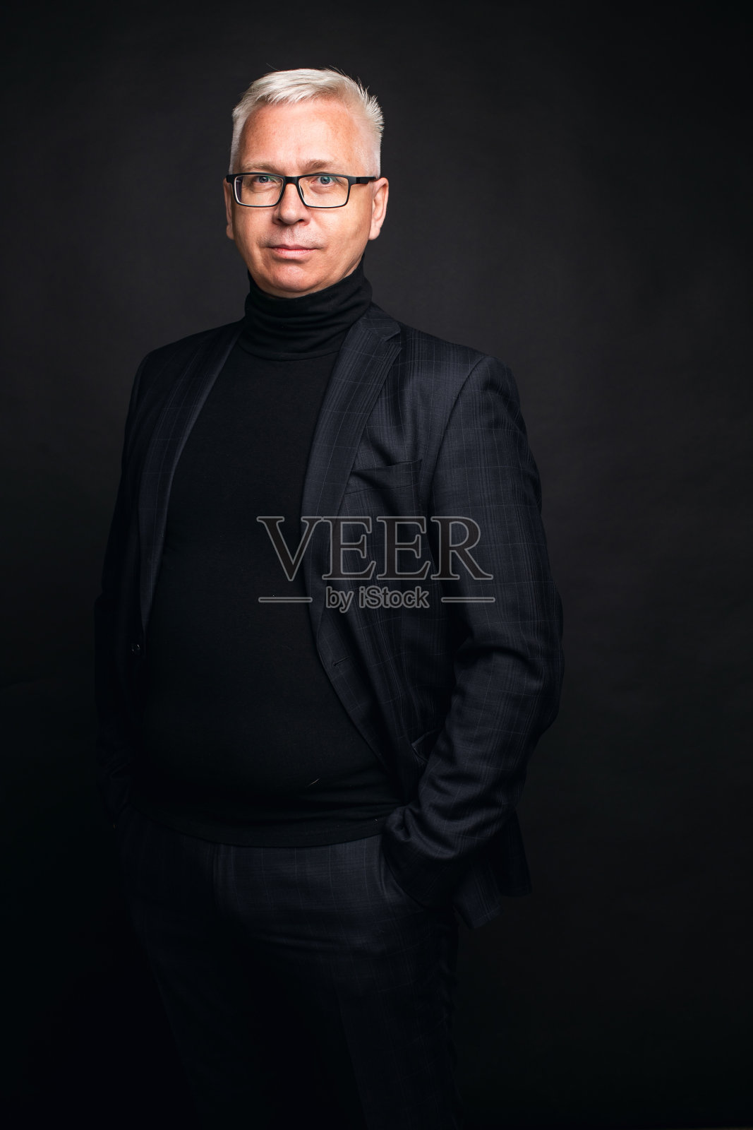 一幅中年男子的肖像,头发花白,戴着眼镜,穿着西装照片摄影图片