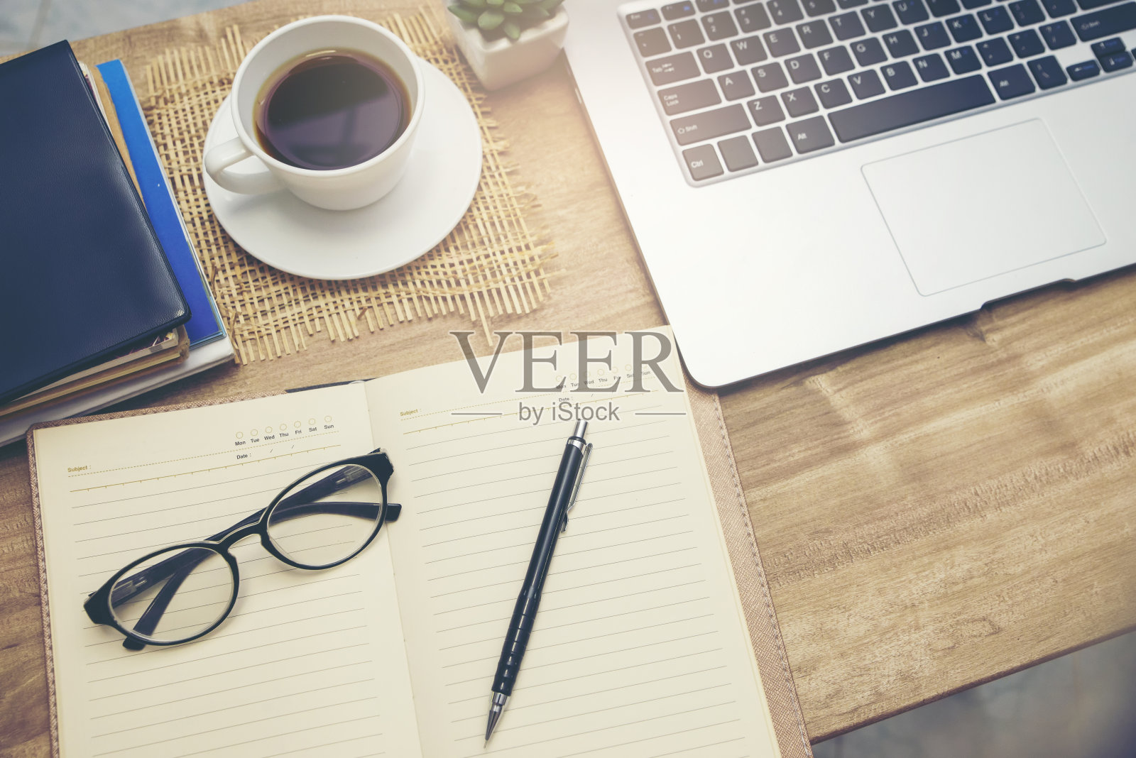 书桌为学生概念。用于考试学习的笔记本电脑,用于学生在家在线工作的课本放在学校桌子上。台式笔记本、笔记本、书杯或咖啡放在木桌上。照片摄影图片